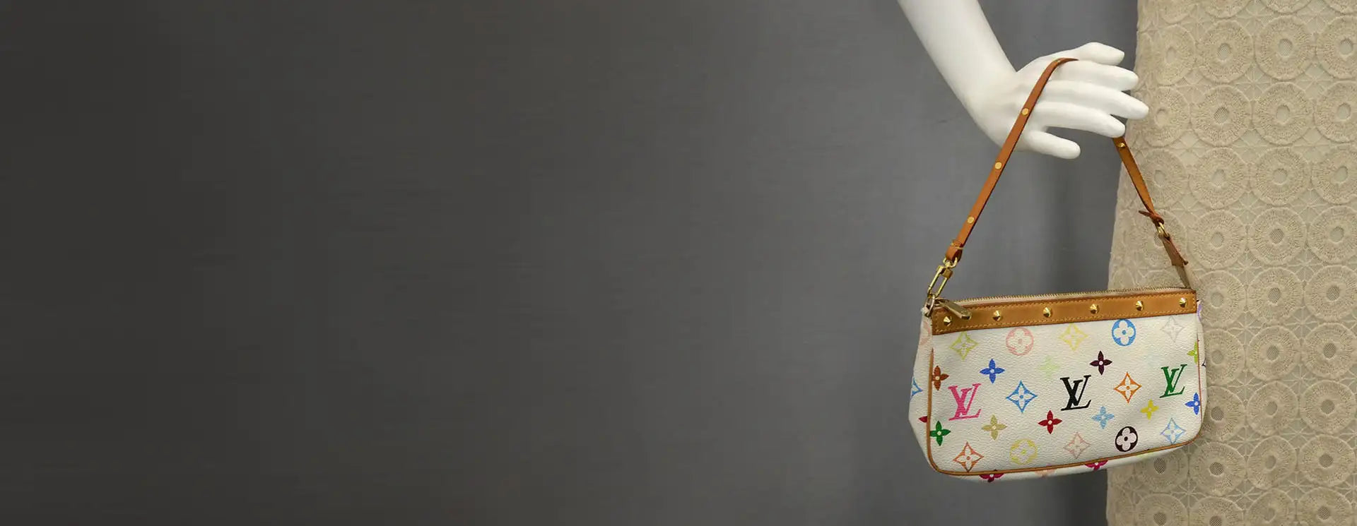 White louis vuitton handbag with colorful monogram pattern and tan leather straps.